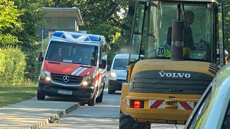 Ein Rettungswagen weicht einem Baufahrzeug bei Bauarabeiten in der Waldstraße in Rüdersdorf aus